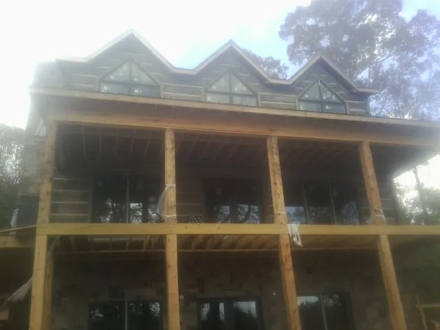 Dormers and porch framing on a large log home under construction — Roof Coating work by our crew in Waynesboro